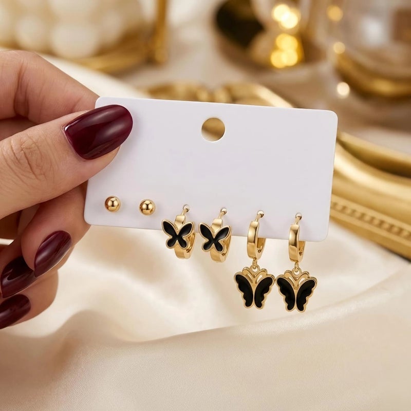 A set of 3 pairs of distinctive gold earrings: gold ball screw, black butterfly-adorned hoops, and a larger, luxurious butterfly pendant. Made of rust-resistant stainless steel for a brilliant shine. - Image 4